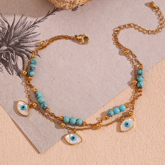 Cavigliera geometrica alla moda in acciaio inossidabile con placcatura in oro 18 carati, occhi in conchiglia di abalone bianco e accenti turchesi blu