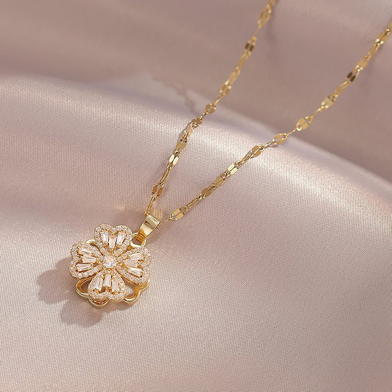 Collana con ciondolo a quadrifoglio rotante da donna in acciaio al titanio con zirconi bianchi micro-incastonati e placcatura in oro su catena ondulata