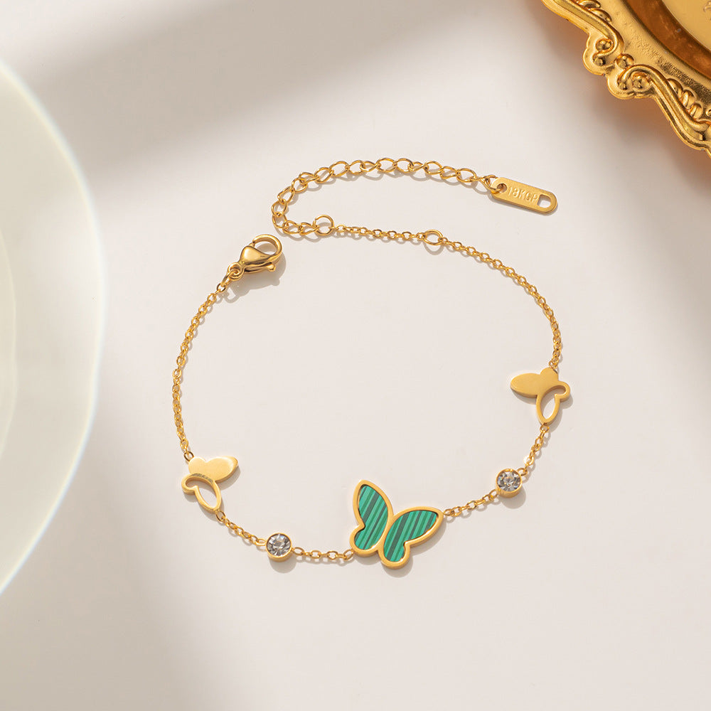 Pulsera minimalista con forma de mariposa de acero de titanio con incrustaciones de nácar y detalles de pedrería, diseño calado con baño de oro para un color duradero