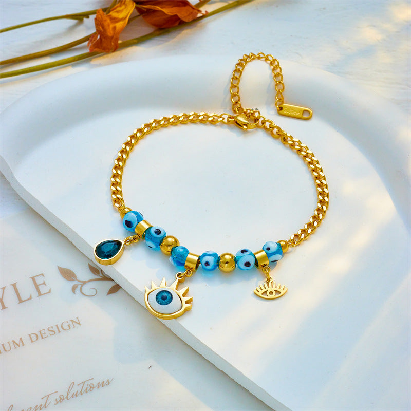 Bracciale alla moda con ciondolo a goccia asimmetrico a forma di occhio blu con perline in acciaio al titanio placcato per donne e uomini