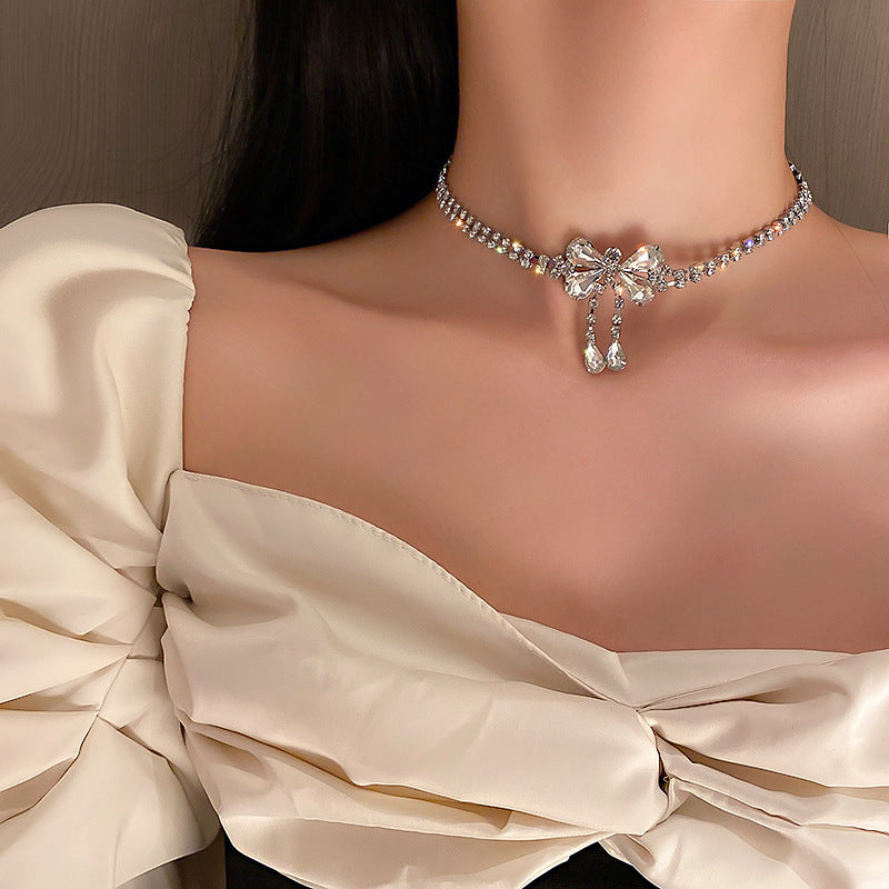 Elegante collar con colgante de lazo de diamantes de imitación y detalles de nácar perlado para mujer — Delicada cadena para clavícula en estilo de lujo minimalista y a la moda