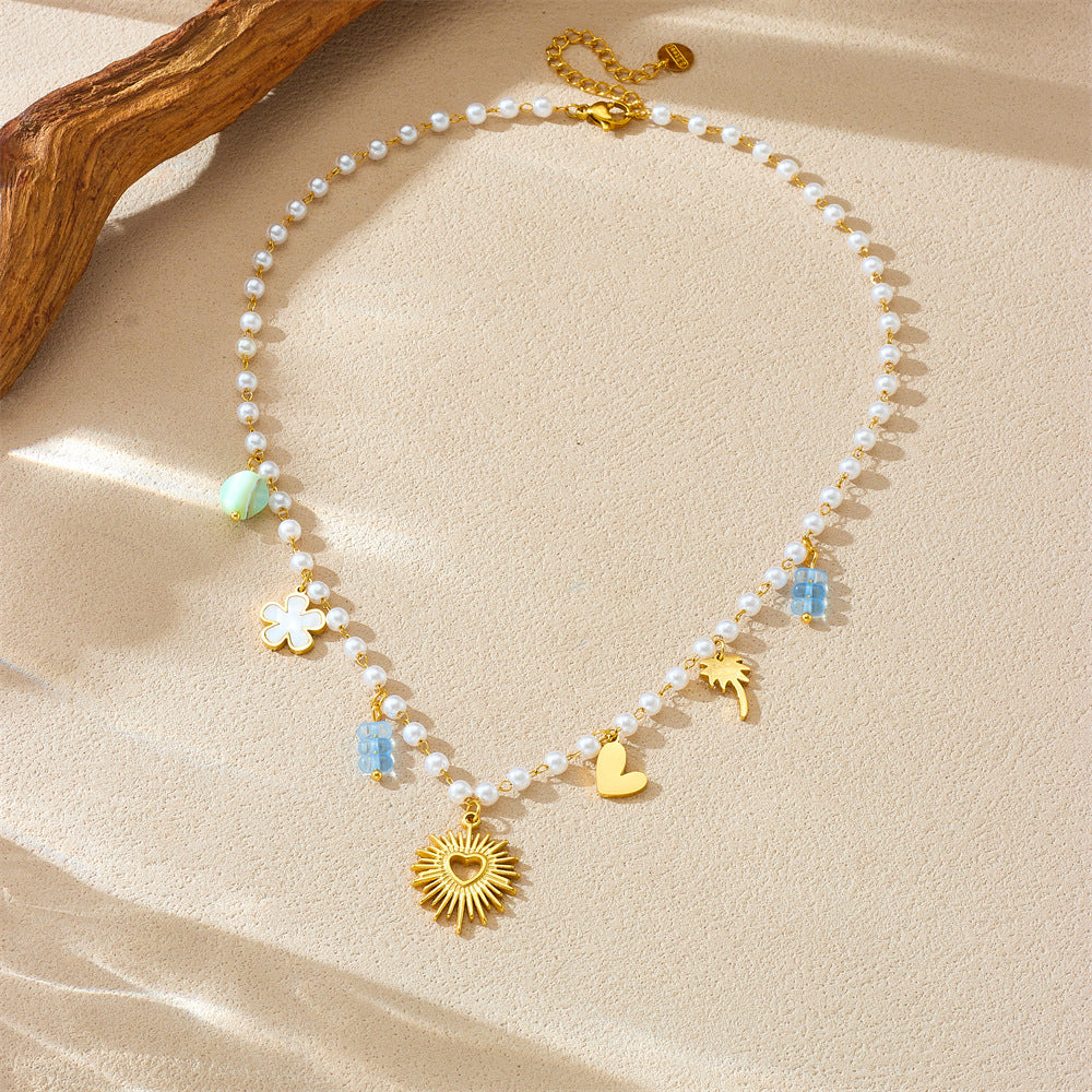 Collana pendente minimalista a forma di cuore in acciaio inossidabile con catena di perle e dettagli floreali e palma da cocco