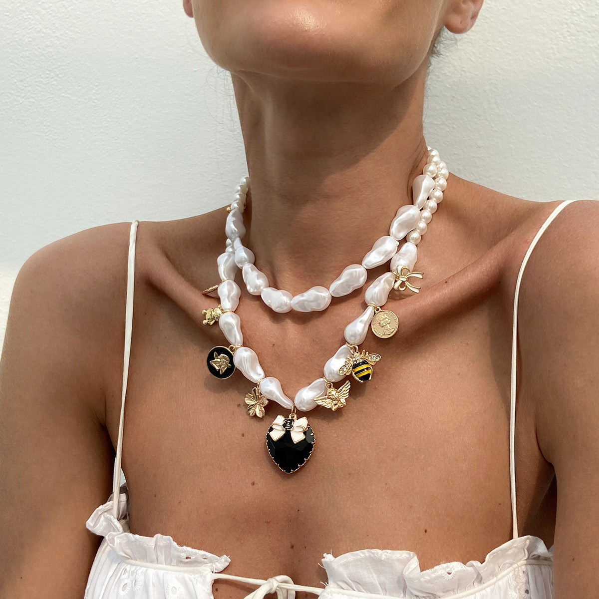 Collana con pendente a forma di ape esagerata a cuore e forma geometrica con base in lega placcata, perle imitate e intarsi in strass acrilici per donna