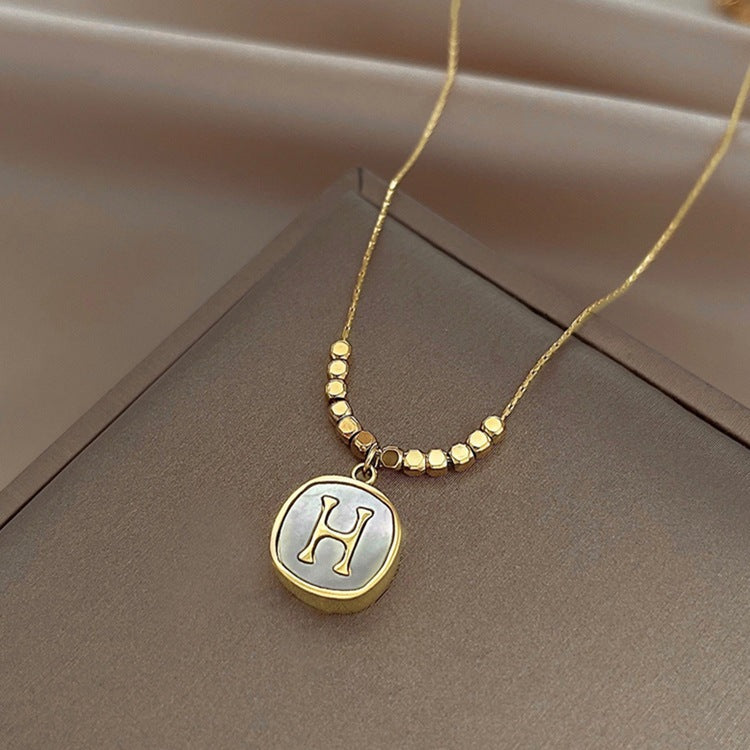 Collana con pendente a faccina sorridente minimalista da donna in acciaio al titanio con intarsio in madreperla e finitura placcata