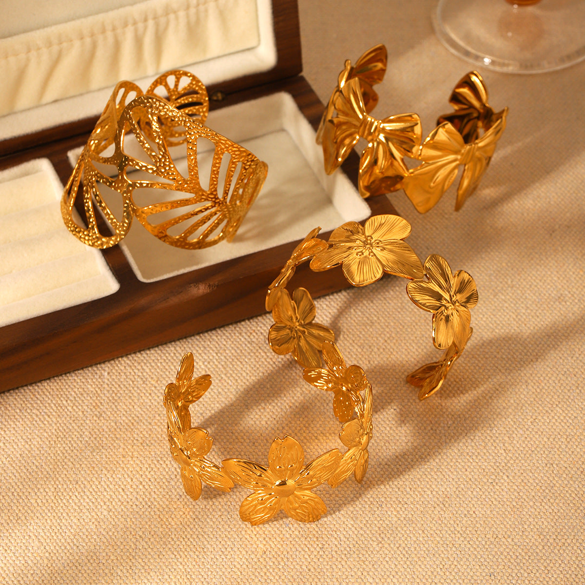 Trendy 18K Gold Plated Stainless Steel Open Cuff Bracelet with Hollow Leaf Flower Bowknot Design