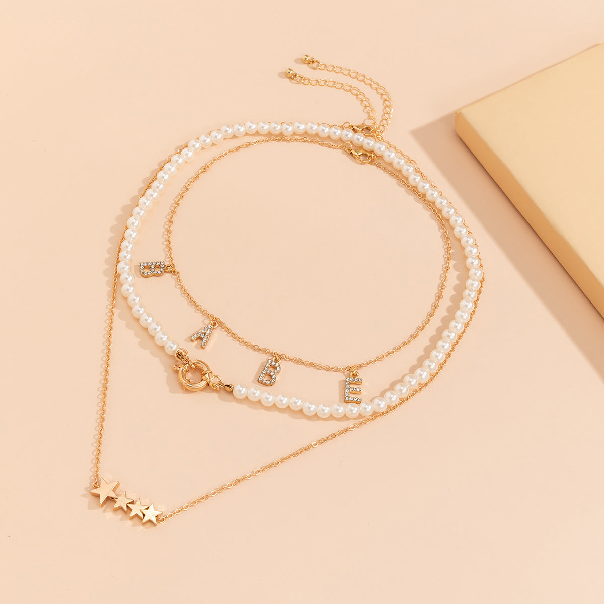 Collana da donna personalizzata con nappa a forma di stella geometrica, lettera e strass, perle sintetiche e catena di perline