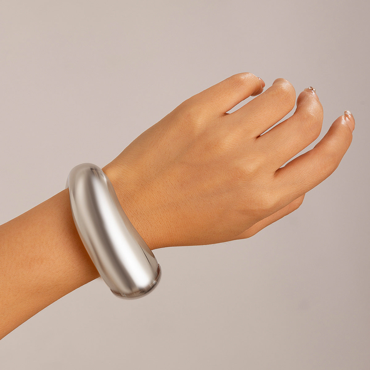 Bracciale a manetta in metallo lucidato a forma di goccia d'acqua oversize con finitura a specchio e design geometrico