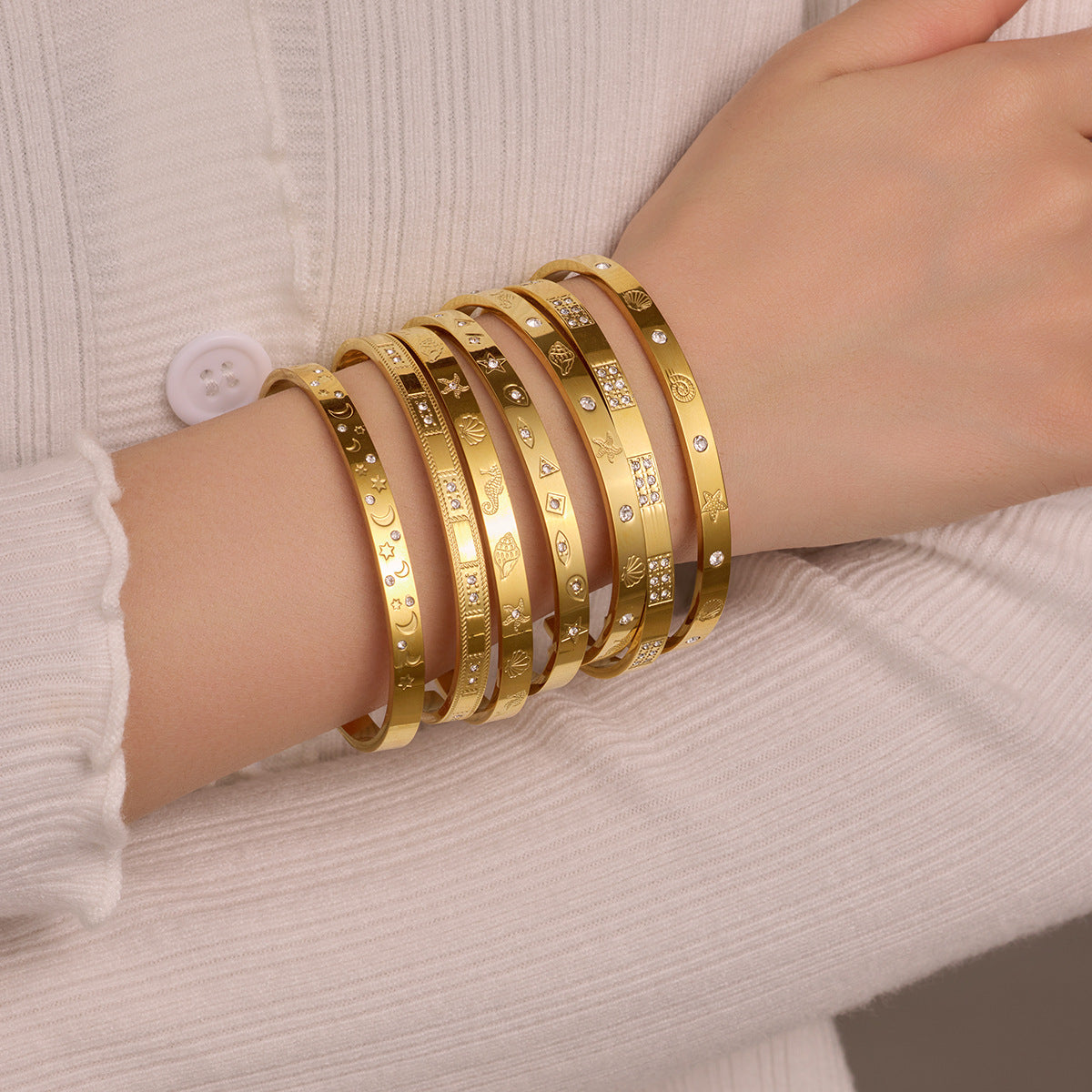 Brazalete abierto de acero de titanio con diseño geométrico, inspirado en el océano, con incrustaciones de pedrería y acabado chapado