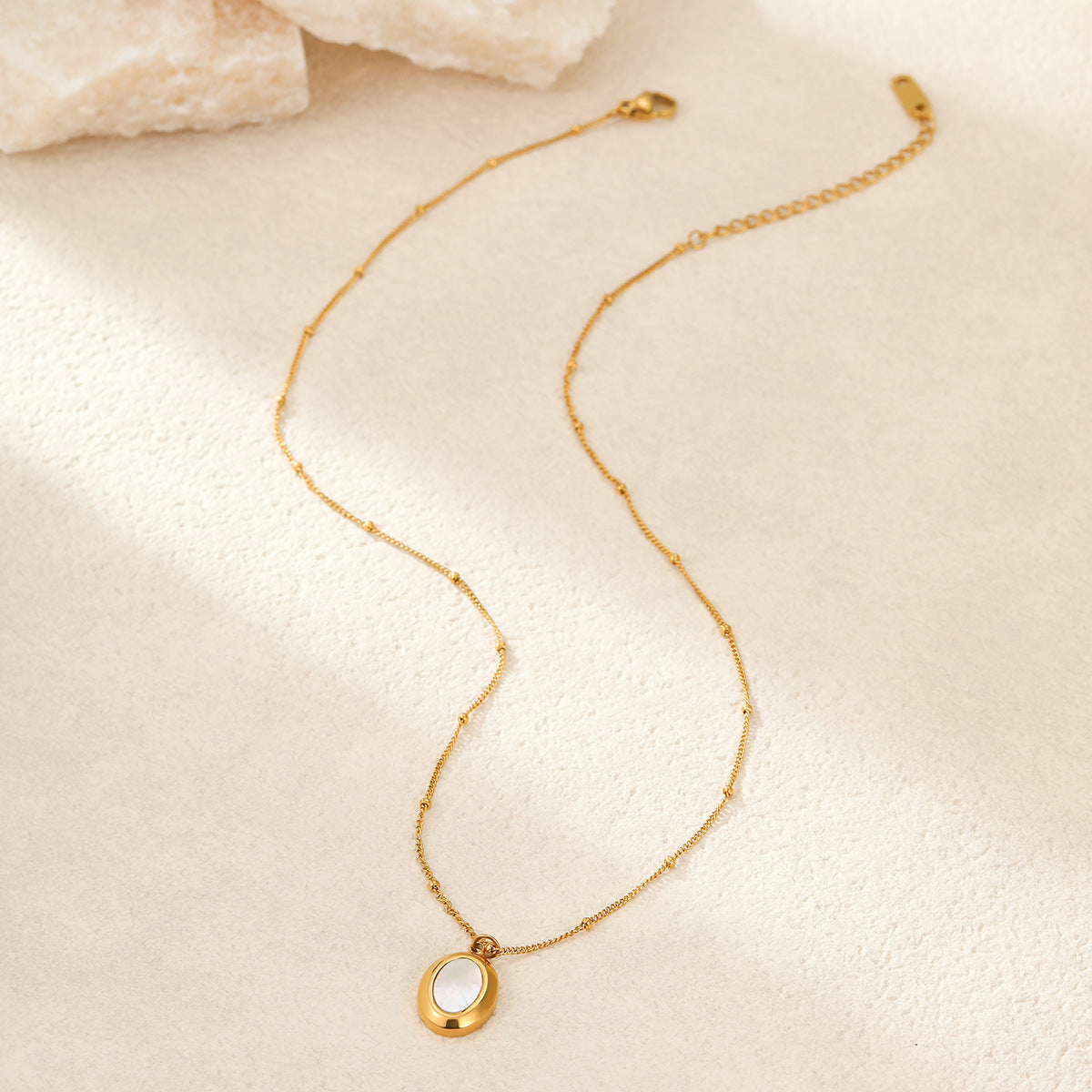 Collar con colgante ovalado geométrico minimalista de abulón blanco en acero de titanio con acabado chapado para mujer