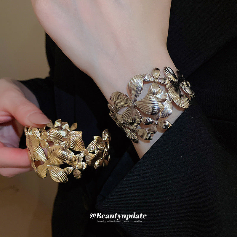 Elegante pulsera de banda ancha calada con forma de flor para mujer con acabado metálico chapado, estilo de oficina a la moda