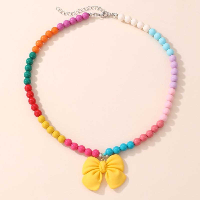 Lindo Collar de Resina con Forma de Lazo para Niñas con Acabado Pintado en Diseño Multicolor, Joyería Infantil Dulce y Juguetona