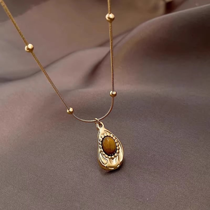 Collana da donna stile vintage in acciaio al titanio placcato oro con pendente irregolare geometrico in ambra, catena per clavicola