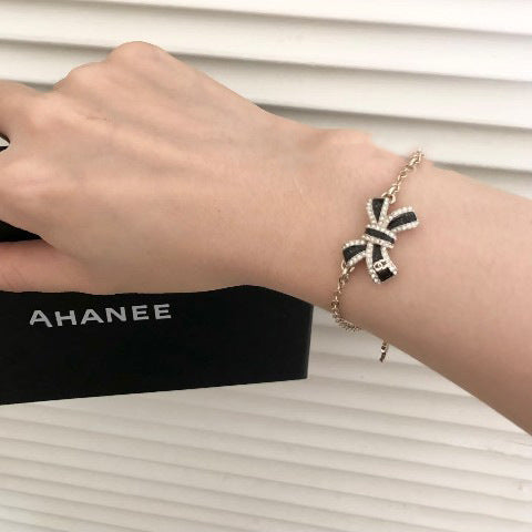 Elegante set di collana e orecchini in ottone placcato oro con fiocco smaltato da donna