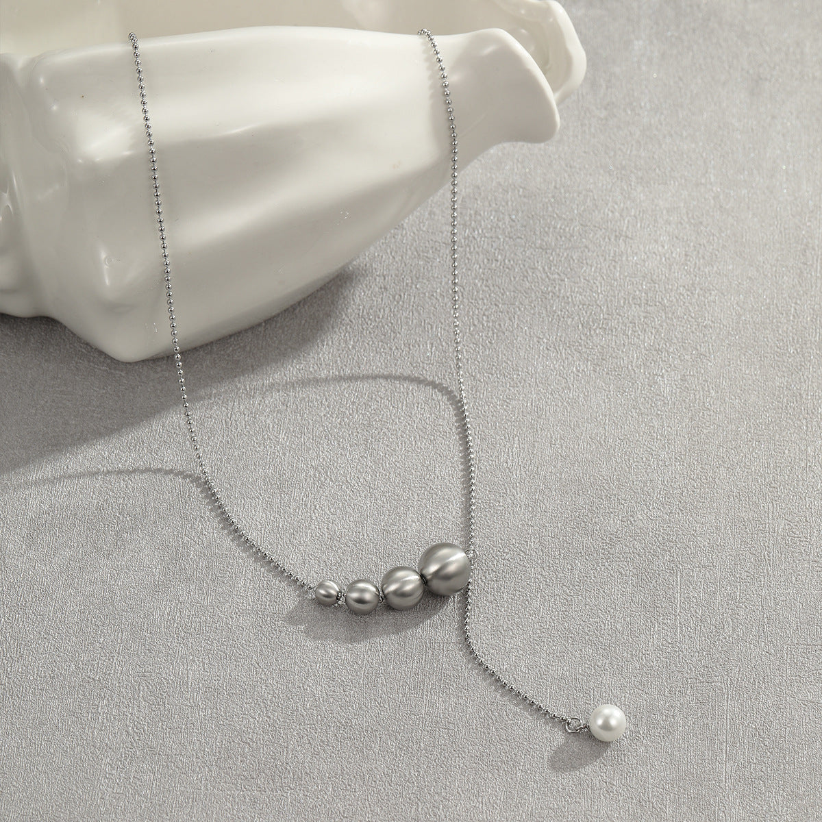 Collana da donna alla moda con perline a occhio di gatto in acciaio al titanio spazzolato con pendente geometrico placcato in oro 18 carati e delicata catena clavicolare