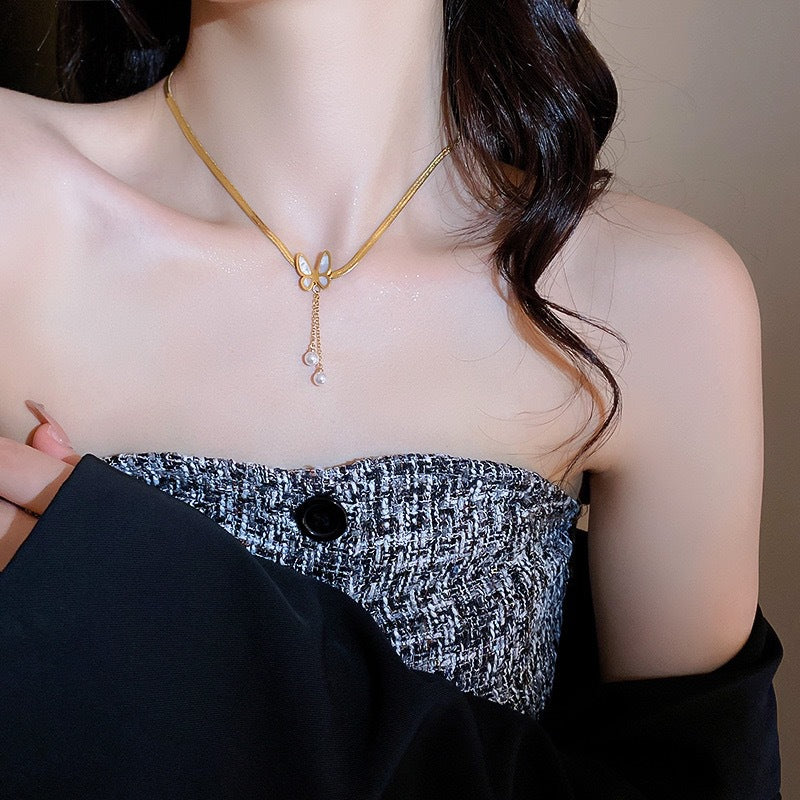 Collana Pendente Minimalista a Forma di Farfalla in Acciaio al Titanio con Accenti di Perle e Nappe per Donna