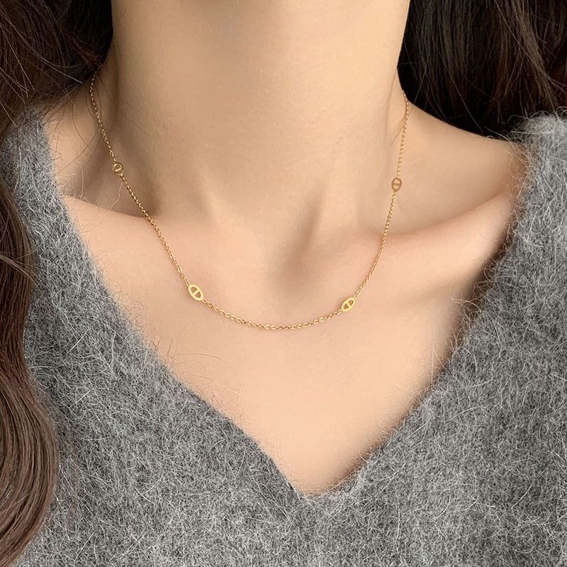 Collana con pendente a naso di maiale in acciaio al titanio placcato oro, tono freddo e minimalista, da donna, con catena a O e design che esalta le clavicole