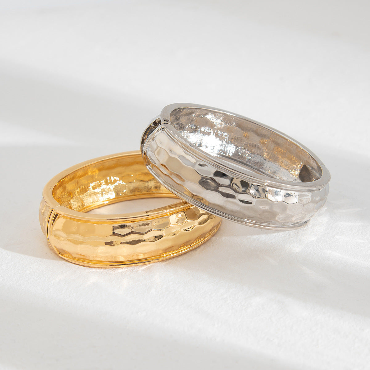 Bracciale rigido aperto da donna minimalista geometrico con texture martellata e chiusura a molla