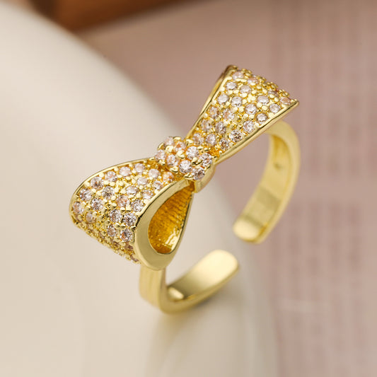 Elegante y delicado anillo de cobre con baño de oro de 18 quilates y diseño de lazo con microcirconitas para mujer