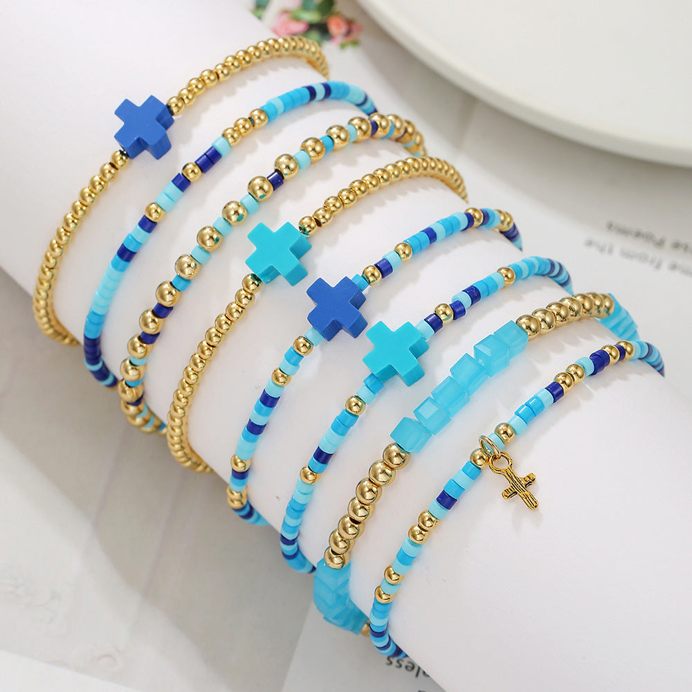 Bracciale minimalista da donna con ciondolo a croce, perline di riso e accenti in argilla polimerica, design elastico impilabile multistrato