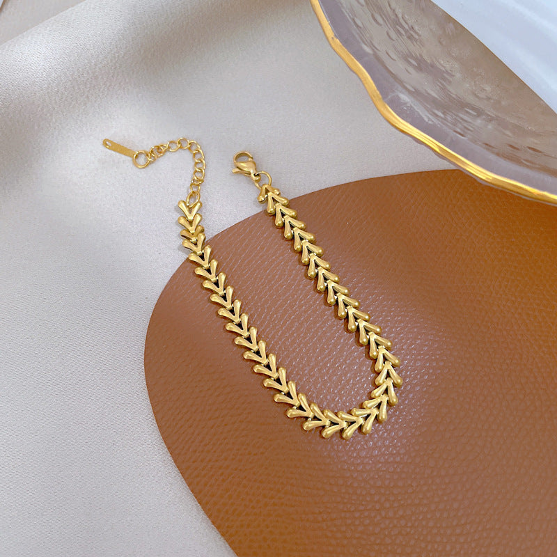 Bracciale da donna minimalista a V in acciaio al titanio con intarsio color oro e trama ondulata