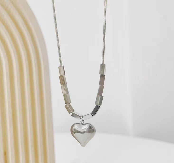 Collana girocollo con ciondolo a cuore geometrico minimalista per donna, in acciaio al titanio con catena a serpente