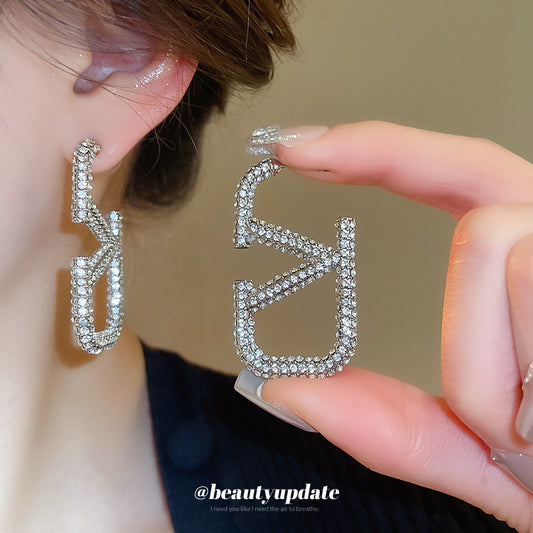 Elegantes pendientes de tuerca de aleación con forma de letra para mujer, con incrustaciones de diamantes de imitación, joyas de moda de aspecto lujoso