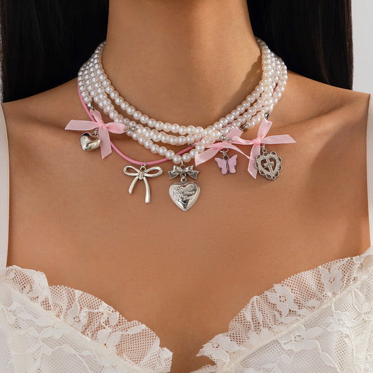 Dulce collar minimalista de corazón y lazo para mujer con detalles de perlas de imitación en cadena de cuentas