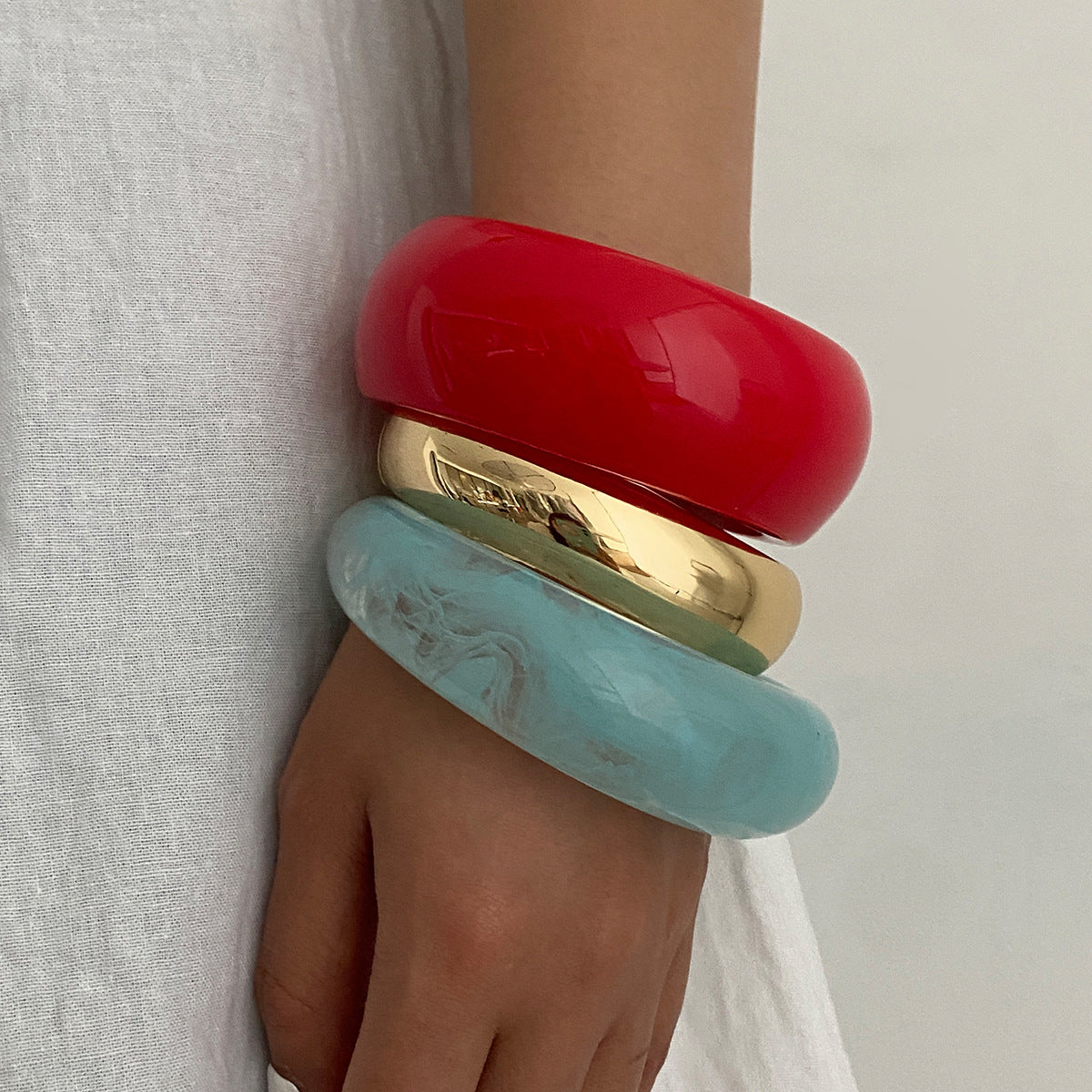 Pulsera geométrica en contraste rojo vivo con acabado pulido y superficie galvanizada para mujer