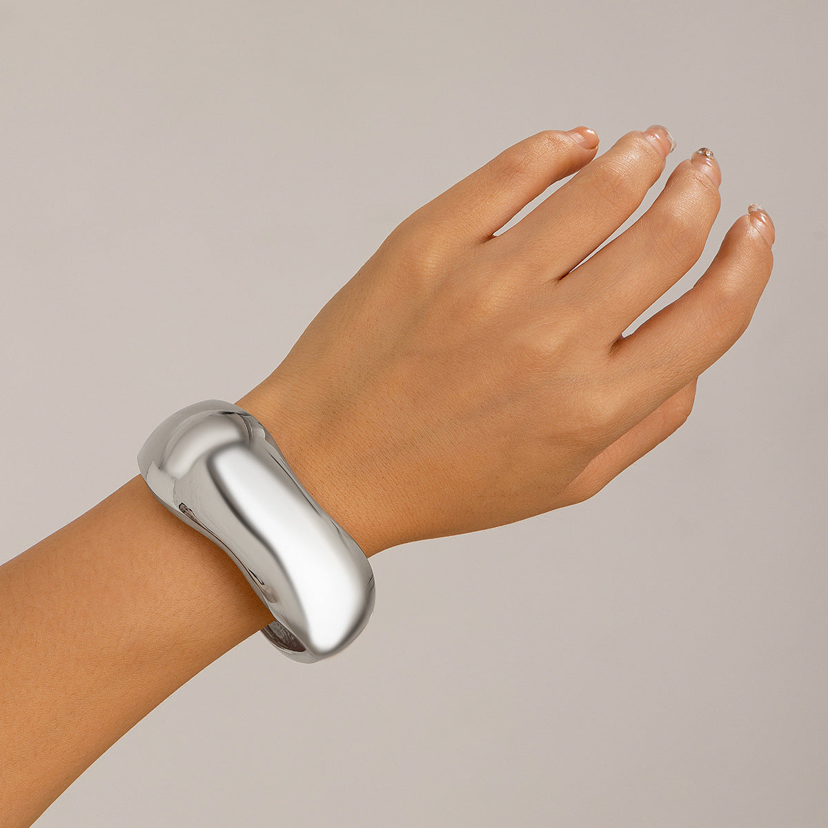 Bracciale a manetta in metallo lucidato a forma di goccia d'acqua oversize con finitura a specchio e design geometrico