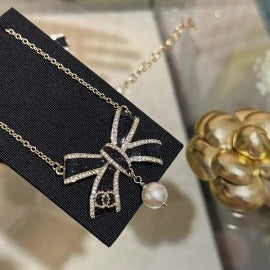 Elegante set di collana e orecchini in ottone placcato oro con fiocco smaltato da donna
