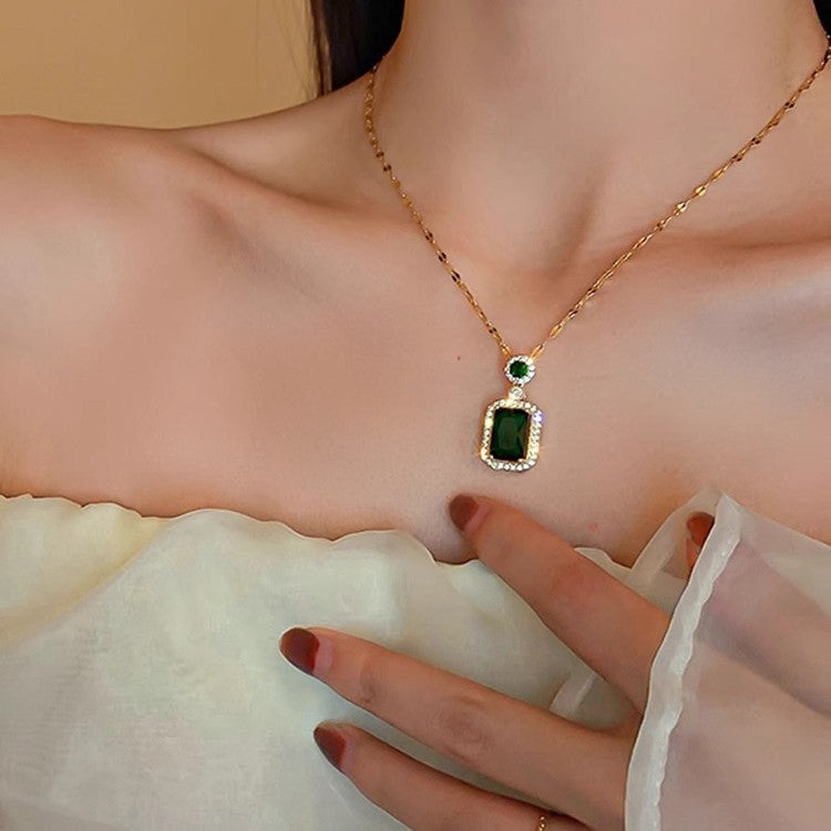 Collana con pendente geometrico di ispirazione vintage in acciaio al titanio con intarsio in rame placcato oro e inserti in cristallo verde su catena a maglie ovali