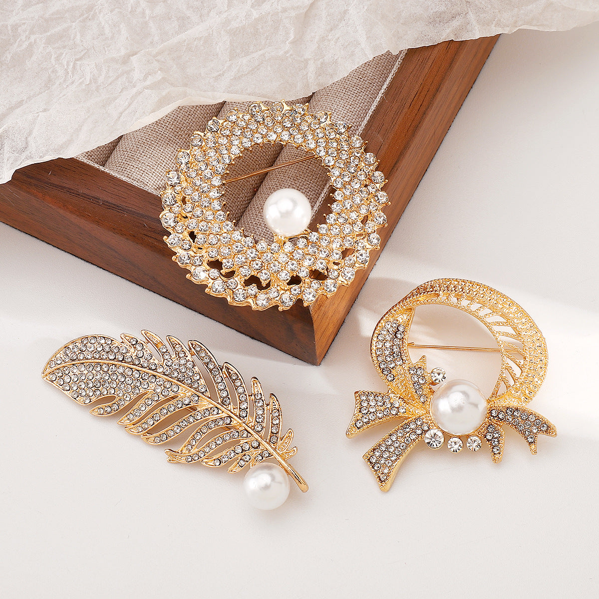 Elegante broche de lujo con incrustaciones de pedrería y detalles de perlas de imitación en base de aleación. Accesorio de moda en forma de pluma para mujer.