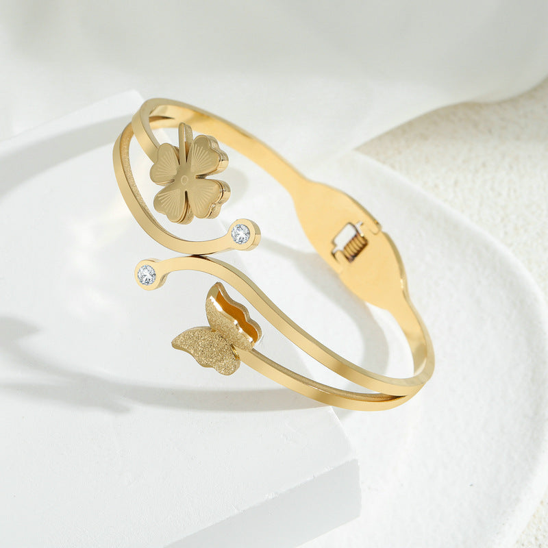 Elegante bracciale aperto in acciaio al titanio placcato oro 18 carati con farfalla e zirconi intarsiati, finitura opaca, da donna