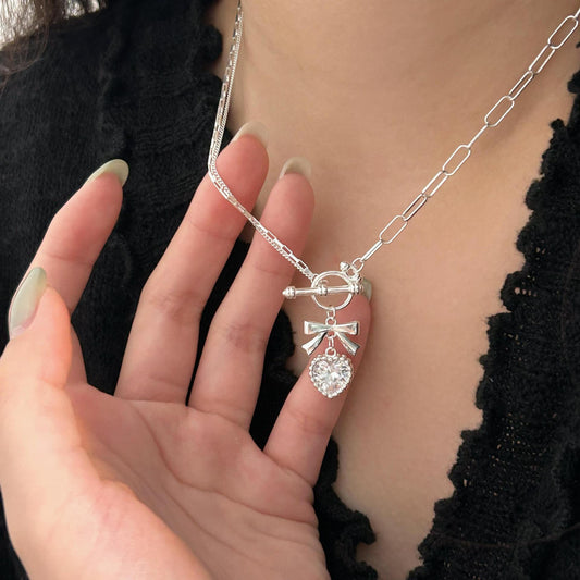 Collar minimalista de plata de ley 925 con forma de lazo y corazón, con detalles de diamantes de imitación en cadena de cruz