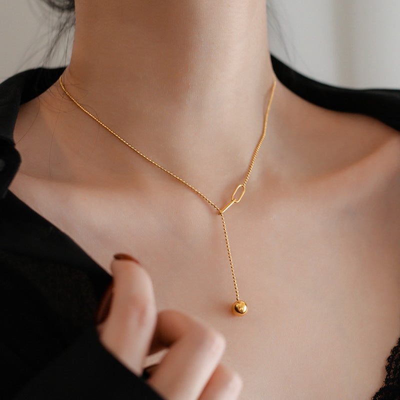 Collana a sospensione geometrica minimalista in acciaio al titanio da donna, con nappa e dettaglio regolabile con sfera a tirante