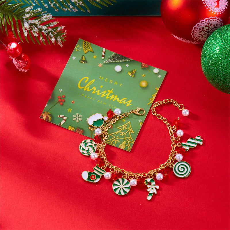 Bracciale artigianale in lega a tema natalizio con ciondolo a forma di Babbo Natale e albero di Natale, perline color caramella, accenti di perle e motivi a fiocco di neve festivi