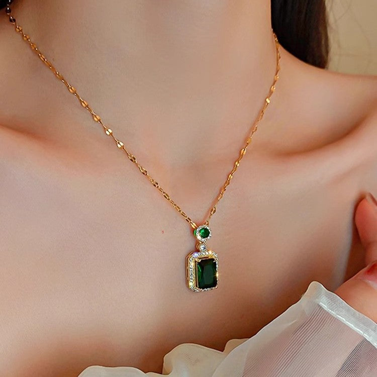 Collana con pendente geometrico di ispirazione vintage in acciaio al titanio con intarsio in rame placcato oro e inserti in cristallo verde su catena a maglie ovali