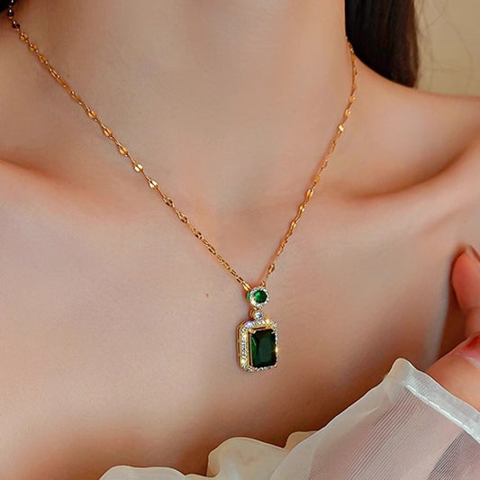 Collana con pendente geometrico di ispirazione vintage in acciaio al titanio con intarsio in rame placcato oro e inserti in cristallo verde su catena a maglie ovali