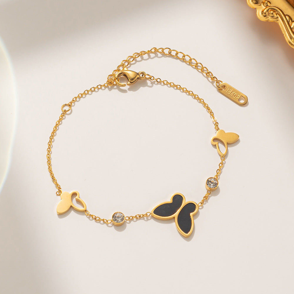 Pulsera minimalista con forma de mariposa de acero de titanio con incrustaciones de nácar y detalles de pedrería, diseño calado con baño de oro para un color duradero