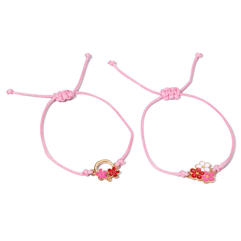 Pulsera infantil de cuerda trenzada con motivo floral y acabado esmaltado en metal de aleación