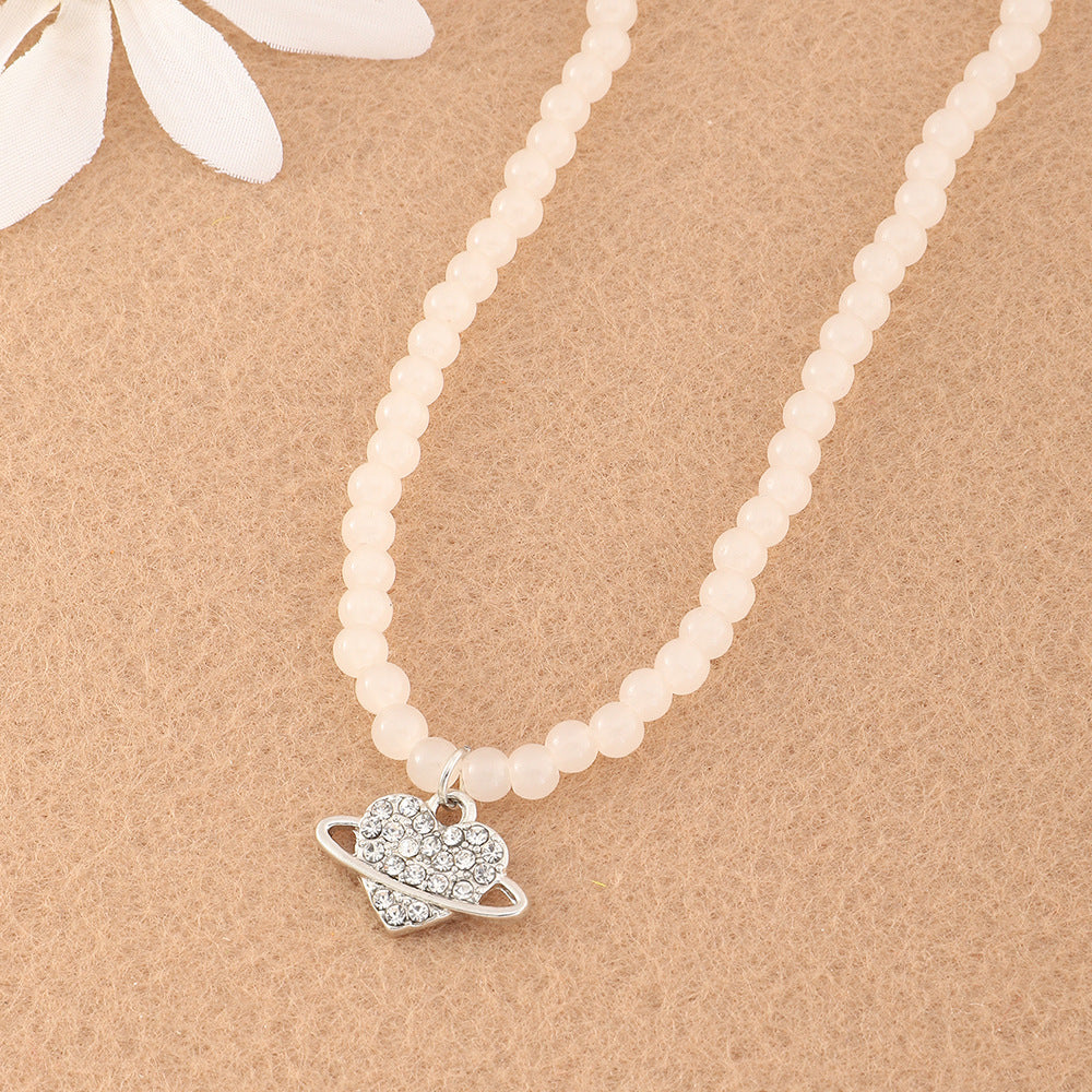 Collana con ciondolo a forma di cuore e pianeta in stile minimalista per ragazze, con perline in resina e intarsi in strass su catena a maglie tonde