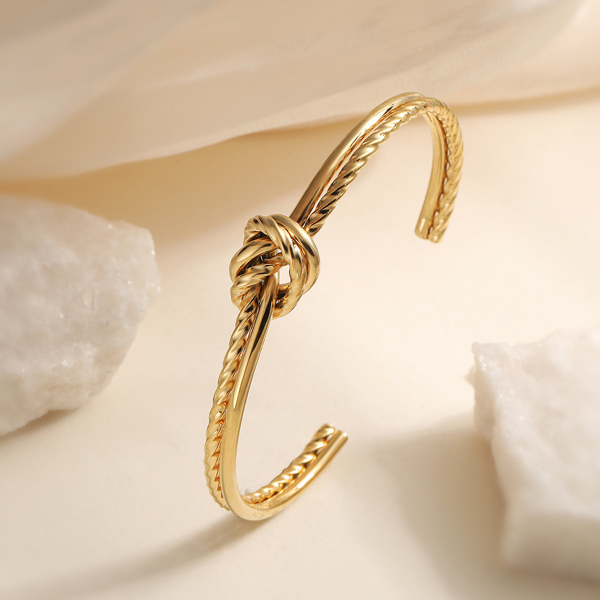 Bracciale minimalista da donna in acciaio inossidabile con apertura a nodo geometrico e finitura placcata