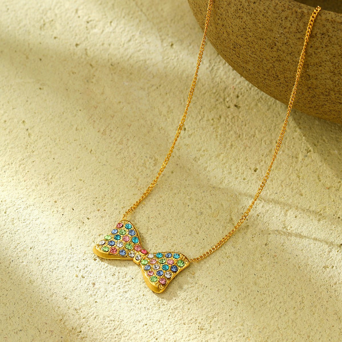 Elegante conjunto de pendientes y collar con forma de lazo de acero de titanio con incrustaciones de pedrería colorida para mujer