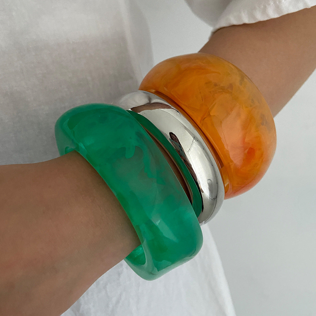 Bracciale minimalista in resina con forme geometriche irregolari, effetto sfumato e finitura placcata