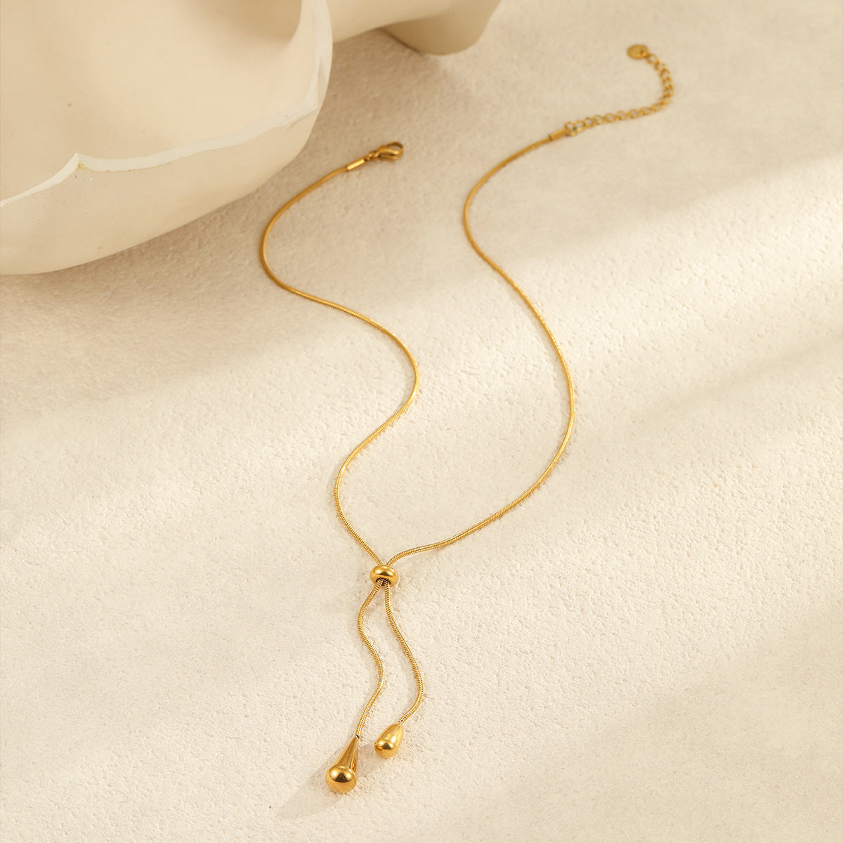 Collar minimalista con colgante de gota de acero de titanio tono frío con baño de oro para mujer
