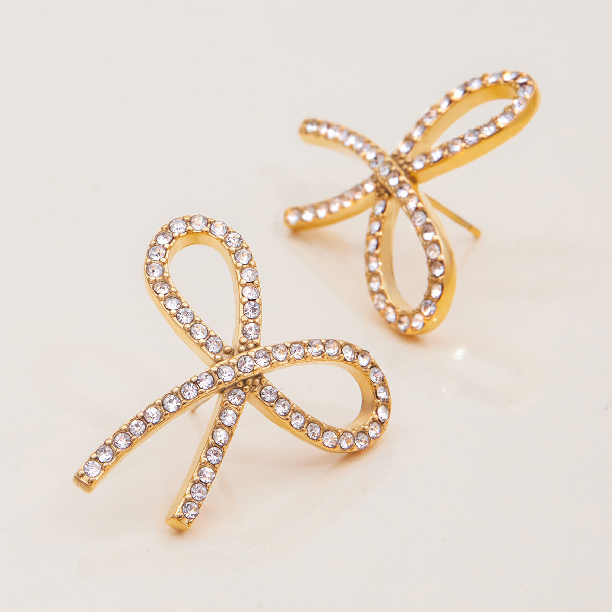 Eleganti orecchini a perno a forma di fiocco in acciaio inossidabile placcati, con strass, da donna