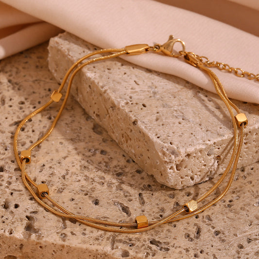 Cavigliera Minimalista Geometrica in Acciaio Inox con Perline Cubiche Placcate Oro 18K e Doppia Catena a Serpente da Donna