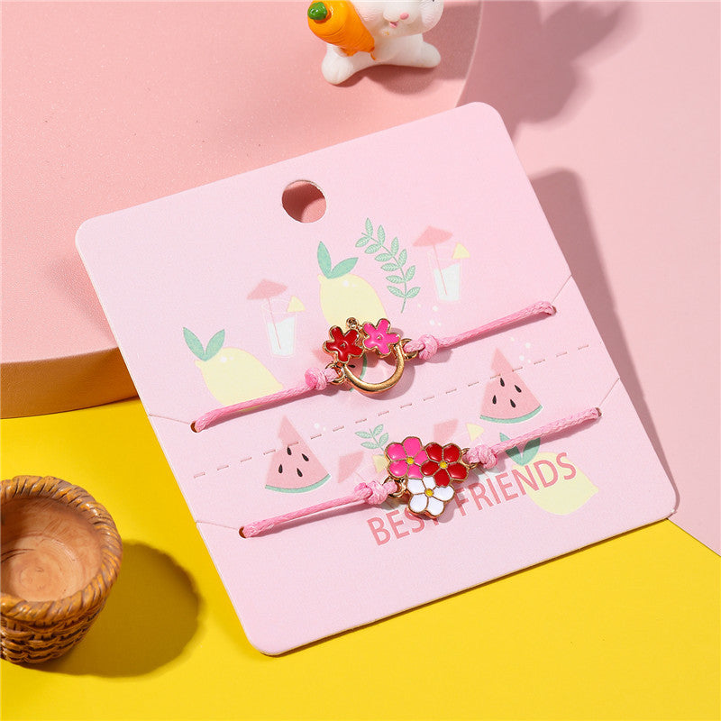 Pulsera infantil de cuerda trenzada con motivo floral y acabado esmaltado en metal de aleación