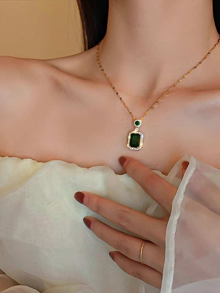 Collana con pendente geometrico di ispirazione vintage in acciaio al titanio con intarsio in rame placcato oro e inserti in cristallo verde su catena a maglie ovali