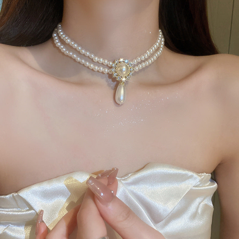 Elegante collar con colgante de lazo de diamantes de imitación y detalles de nácar perlado para mujer — Delicada cadena para clavícula en estilo de lujo minimalista y a la moda